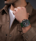 Square watch with clear TR90 case, blue chronograph dial with white markers and red accents, and a green silicone strap.