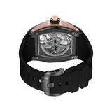 Back view of a gunmetal-toned watch with rose gold-toned accents, a transparent skeleton back, and a black silicone strap wit