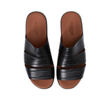 Top-down angled shot of the leather slides showcasing the "Made in Italy" gold-leaf logo on the insole.