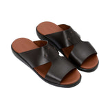 Angled top-down view of the pair of black leather slides, showcasing the "Prestige Made in Italy" gold-stamped logo on the tan insole.