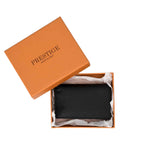 PRESTIGE black leather card holder inside its signature orange gift box with white tissue paper.