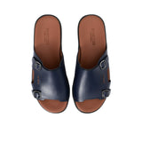Overhead view of a pair of PRESTIGE navy blue leather slide sandals with tan footbeds and silver buckles.