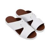 Angled top-down view of the pair of black leather slides, showcasing the "Prestige Made in Italy" gold-stamped logo on the tan insole.