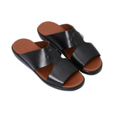Angled top-down view of the pair of black leather slides, showcasing the "Prestige Made in Italy" gold-stamped logo on the tan insole.