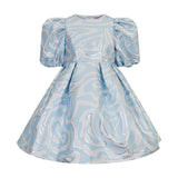 Light blue dress with silver metallic swirling pattern, puffed sleeves, round neck, and a full pleated skirt.