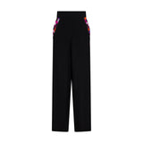Black high-waisted trousers with wide legs and side pockets detailed with a vibrant abstract pattern.