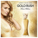 Paris Hilton Gold Rush EDP - 100ml Advertisement for Paris Hilton's Gold Rush perfume with a woman in a gold dress on a glittery gold background.