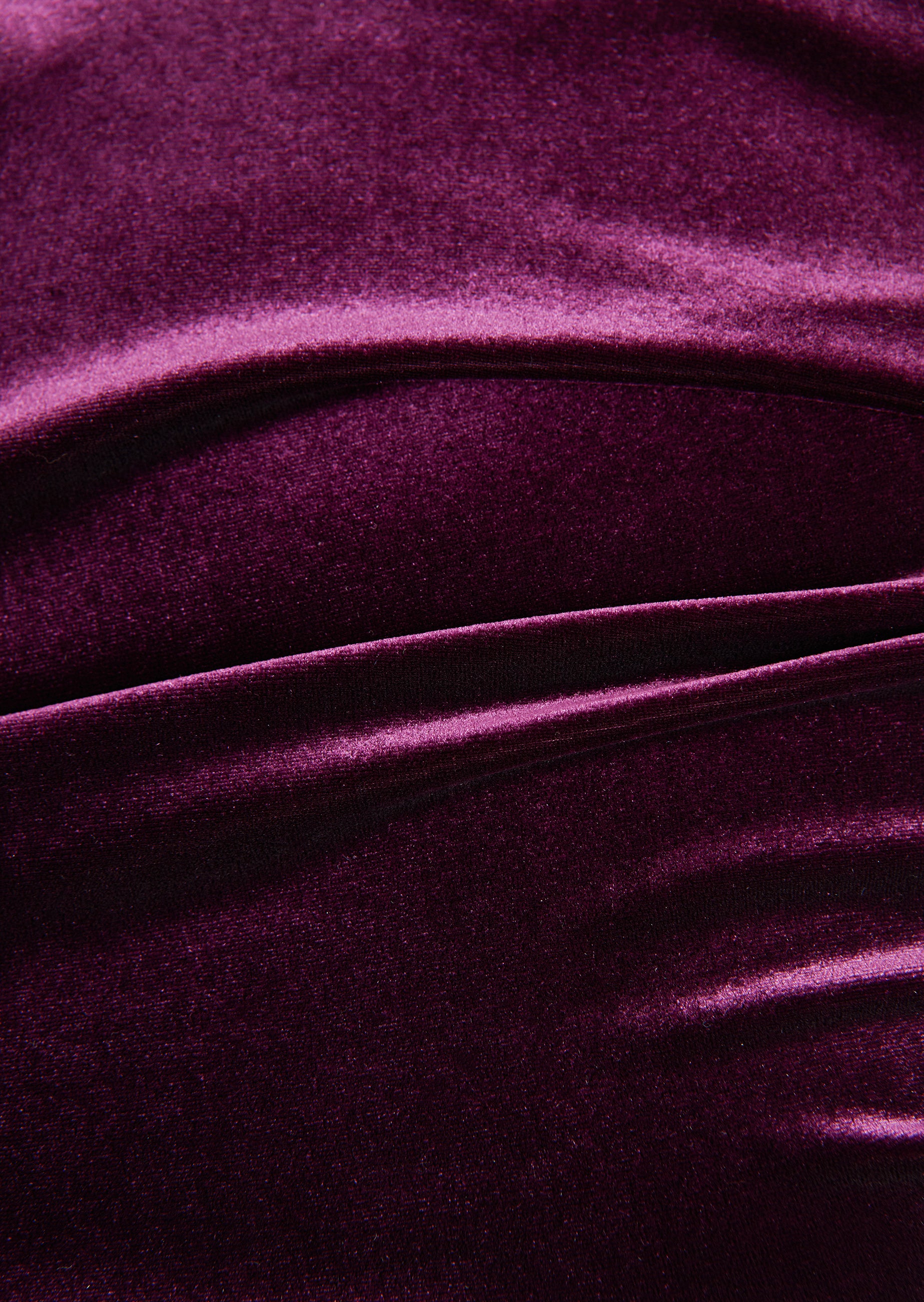 Aubergine velvet fabric with a soft sheen and draped folds.