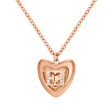A direct macro studio photograph focusing on the Escada Mina heart pendant, highlighting its concentric stepped layers and the central double-E monogram logo flanked by fine crystal rows.