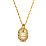 A detailed close-up shot of the gold oval pendant, highlighting the cutout double-E Escada logo motif, the shimmering clear crystal border, and the outer twisted-rope trim.