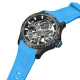 Right-angle perspective view focusing on the layered depth of the skeleton dial, the fluted black setting crown with blue accent ring, and the integrated fit of the light blue sport silicone band.