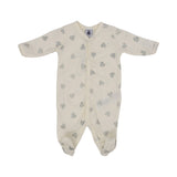 Petit Bateau baby footed onesie in off-white with silver glitter heart pattern and front snap buttons.