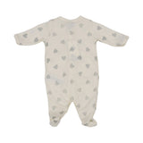 Petit Bateau baby footed onesie in off-white with silver glitter heart pattern and front snap buttons.