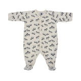 Petit Bateau baby footed onesie in off-white featuring an all-over navy blue zebra print and front snap buttons.