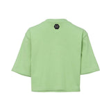 The rear view of a pistachio green cropped T-shirt featuring a small black hexagonal "PP" logo patch below the neckline.