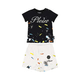 Front view of a Philipp Plein Junior set featuring a black t-shirt with a "Plein" logo and white shorts, both with multi-colored paint splatters.