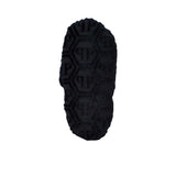 The sole of a single black terry slipper is shown, revealing the entire bottom surface covered in the embossed hexagonal logo pattern for texture and grip.