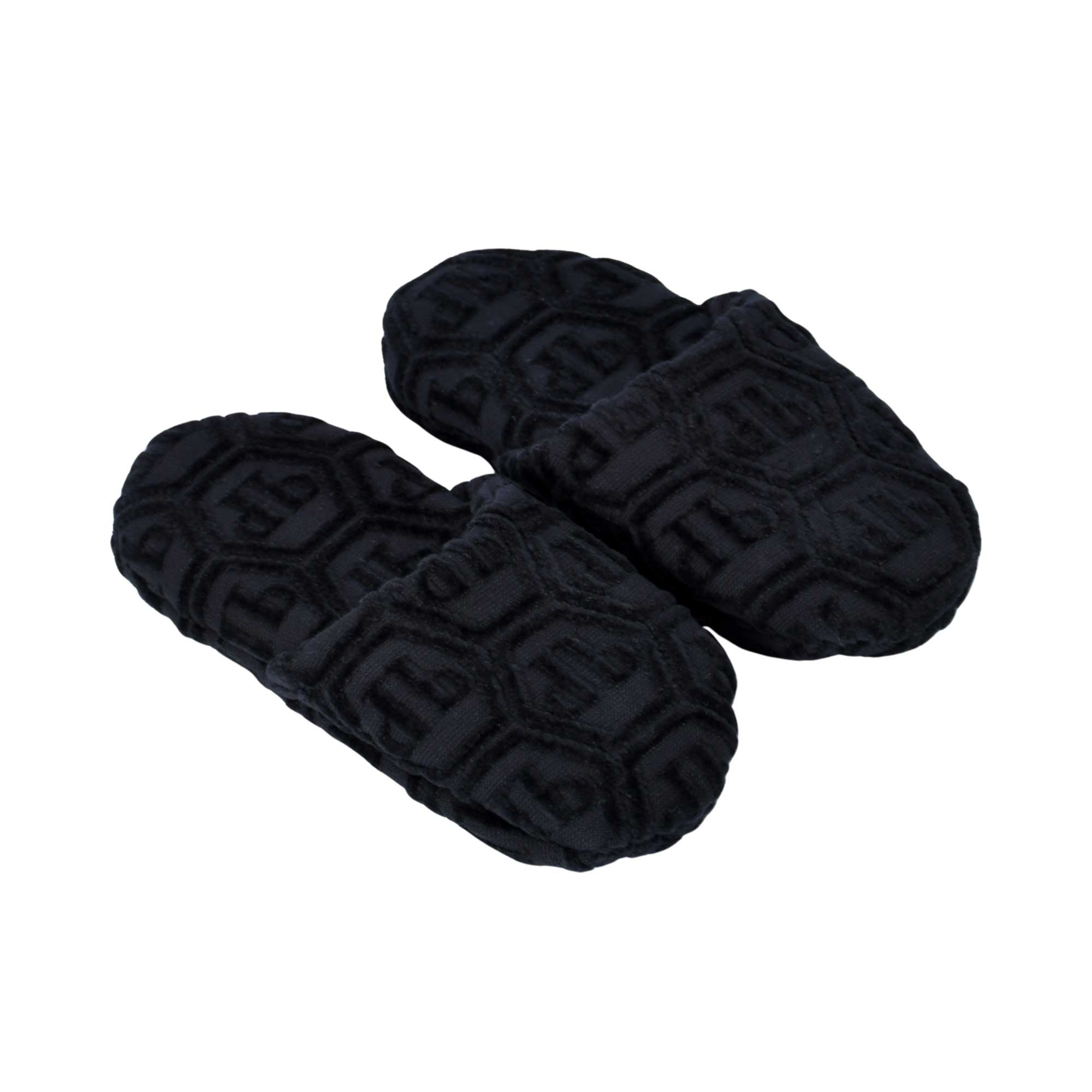 A three-quarter perspective shot from above showing a pair of white terry slippers, capturing both the design of the insole and the texture.