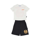 Front view of a Philipp Plein Junior set featuring a white t-shirt with orange chest branding and black shorts with a large orange hexagonal logo.