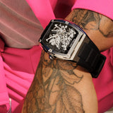 Steel-toned rectangular watch with a black skeleton dial showing internal gears, silver-toned hands and markers, and a black