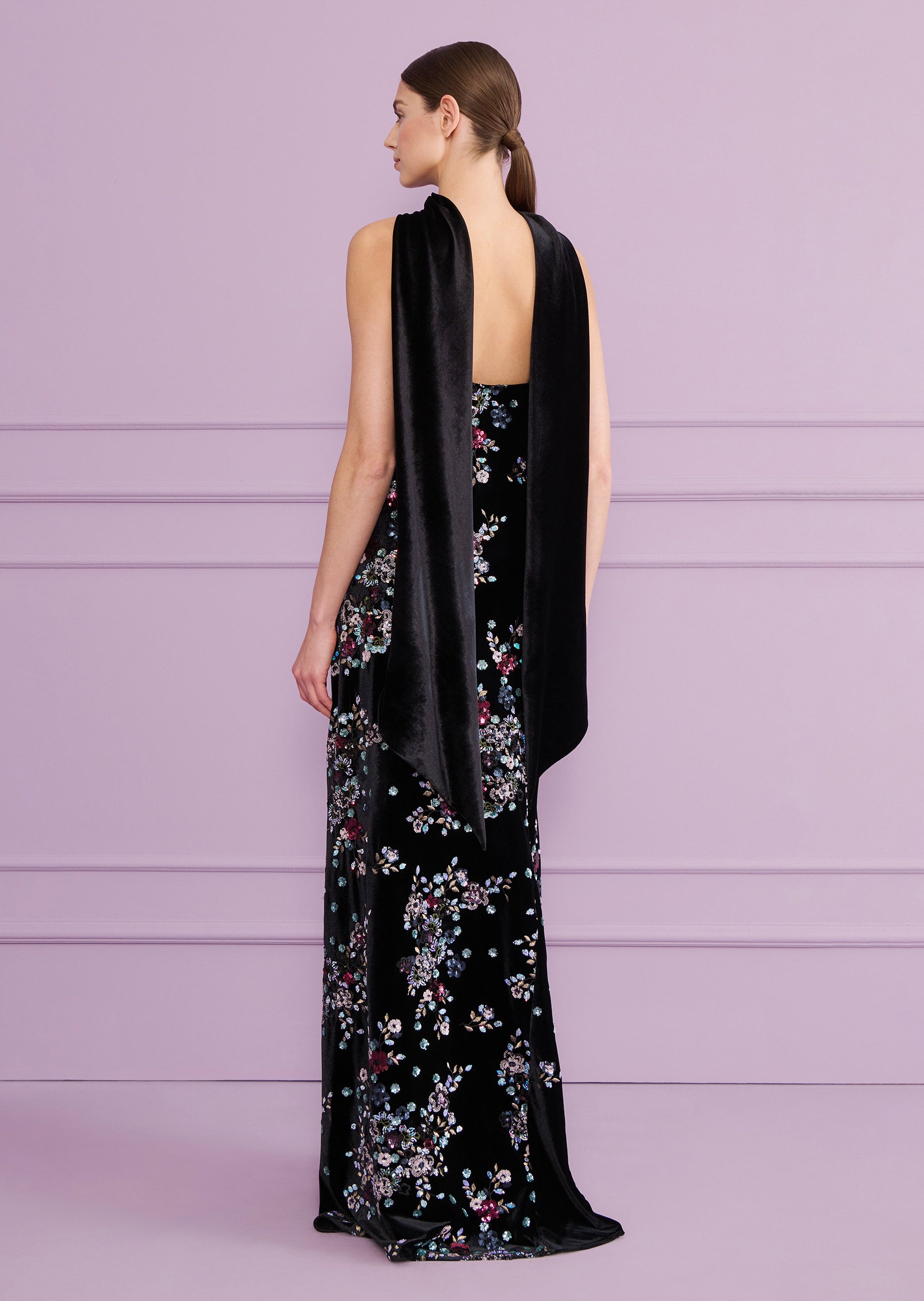 Black velvet long dress with colorful floral pattern. Wide black velvet straps drape over the shoulders and down the back.