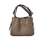 Front view of the Pourchet Blossom bucket bag , showing the adjustable shoulder strap and the gold embossed brand logo on the front.