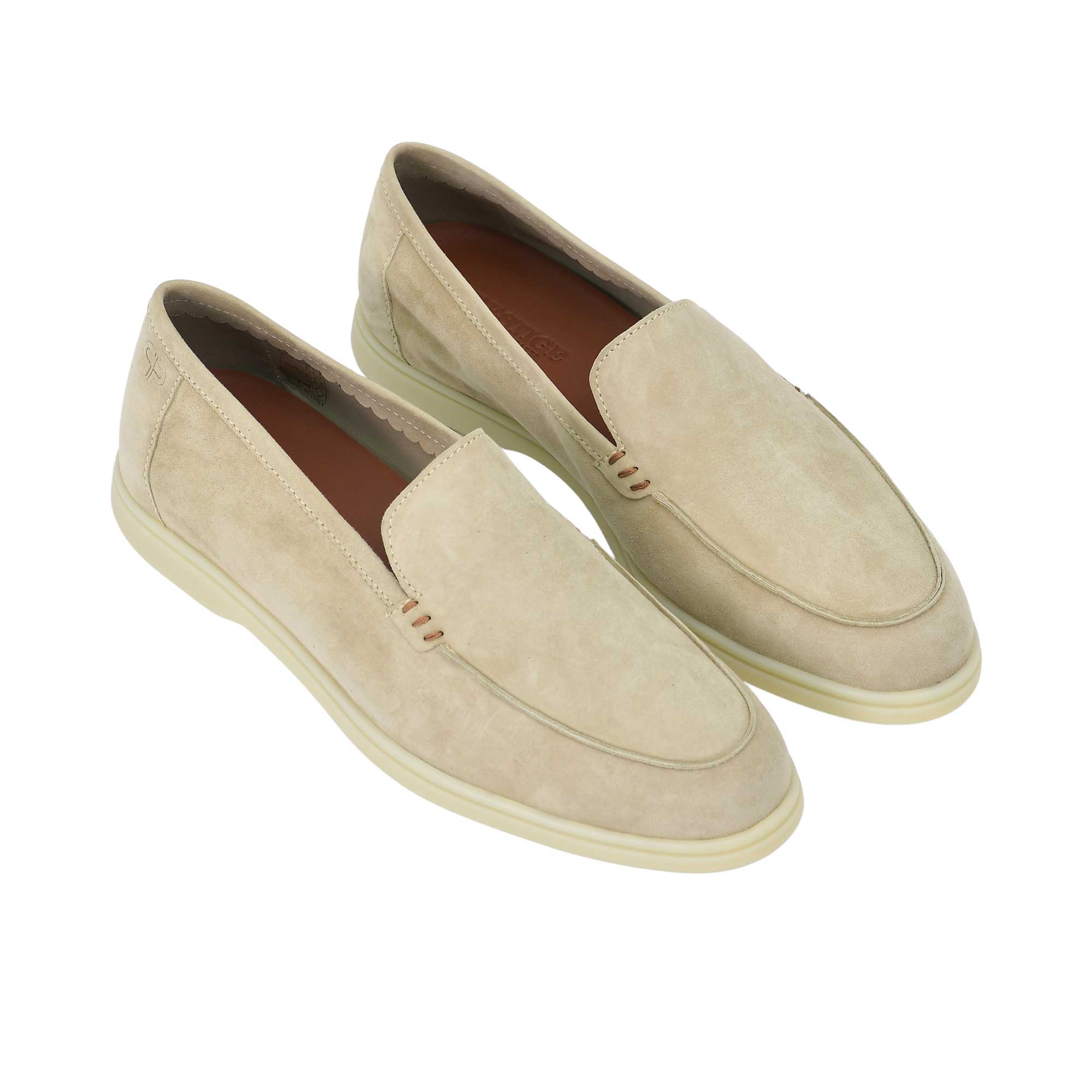 A high-angle, three-quarter perspective of the pair of beige suede loafers. This view highlights the classic apron-toe stitching, the small brown bar-tack style stitch accents at the sides of the tongue, and the contrasting brown leather insoles.