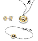 A crisp, professional studio display of the two-tone Aigner Adriana jewelry set on a white background, highlighting the crystal-set horseshoe pendant necklace, matching medallion bracelet with adjustable charm, and the paired round stud earrings.