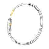 A side profile photograph accentuating the complete circular architecture of the polished rigid steel bangle, the integrated rear case hinge, and the fluted yellow gold setting crown on the side of the horseshoe watch head.