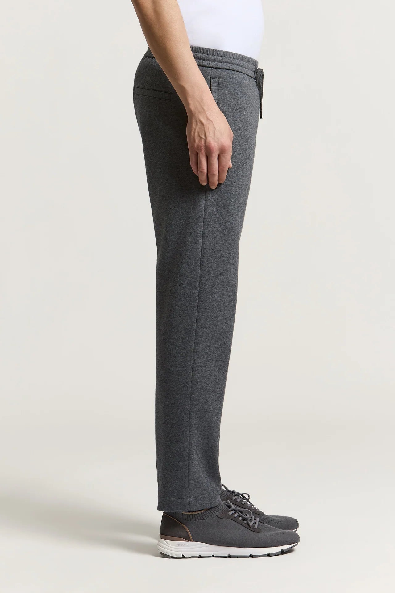 Dark grey straight-leg trousers with an elasticated waistband and a dark drawstring. Made from a smooth, soft fabric.