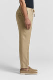 Beige pure linen gabardine trousers with an elasticated drawstring waist, side pockets, a back welt pocket, and cuffed hems.
