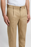 Beige pure cotton gabardine chino trousers with a dark button, belt loops, single front pleats, and side pockets.