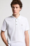 White piquet polo shirt with a classic collar, three light brown buttons, and a gold-toned 'PESERICO 1962' logo. Short sleeve