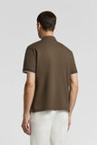 Brown piquet polo shirt with short sleeves and white trim on the cuffs. Back view.
