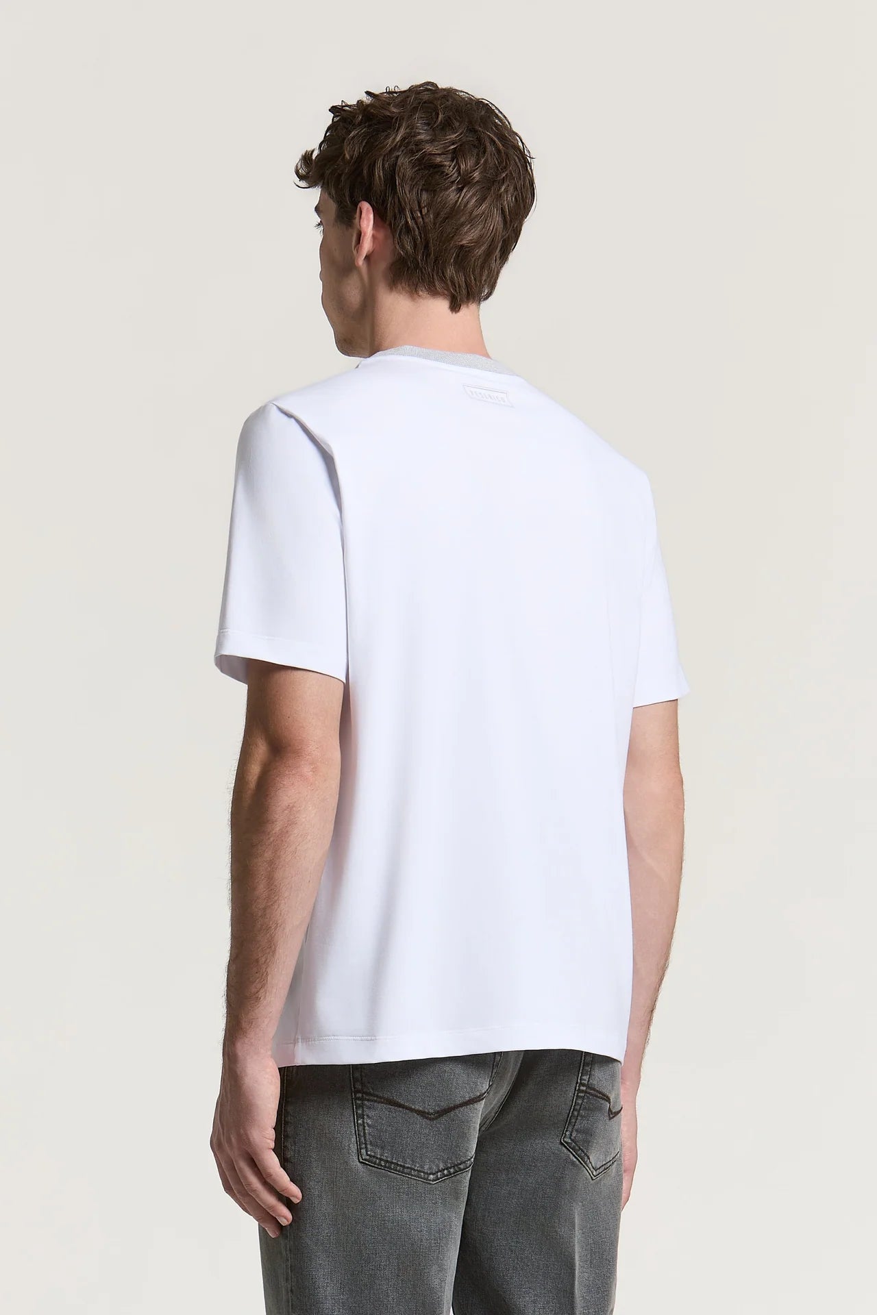 Natural white short-sleeved t-shirt with a light grey inner collar and a subtle embossed logo on the upper back.