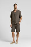 Brown linen canvas camp shirt with short sleeves, an open collar, full button-front, and a single chest patch pocket.