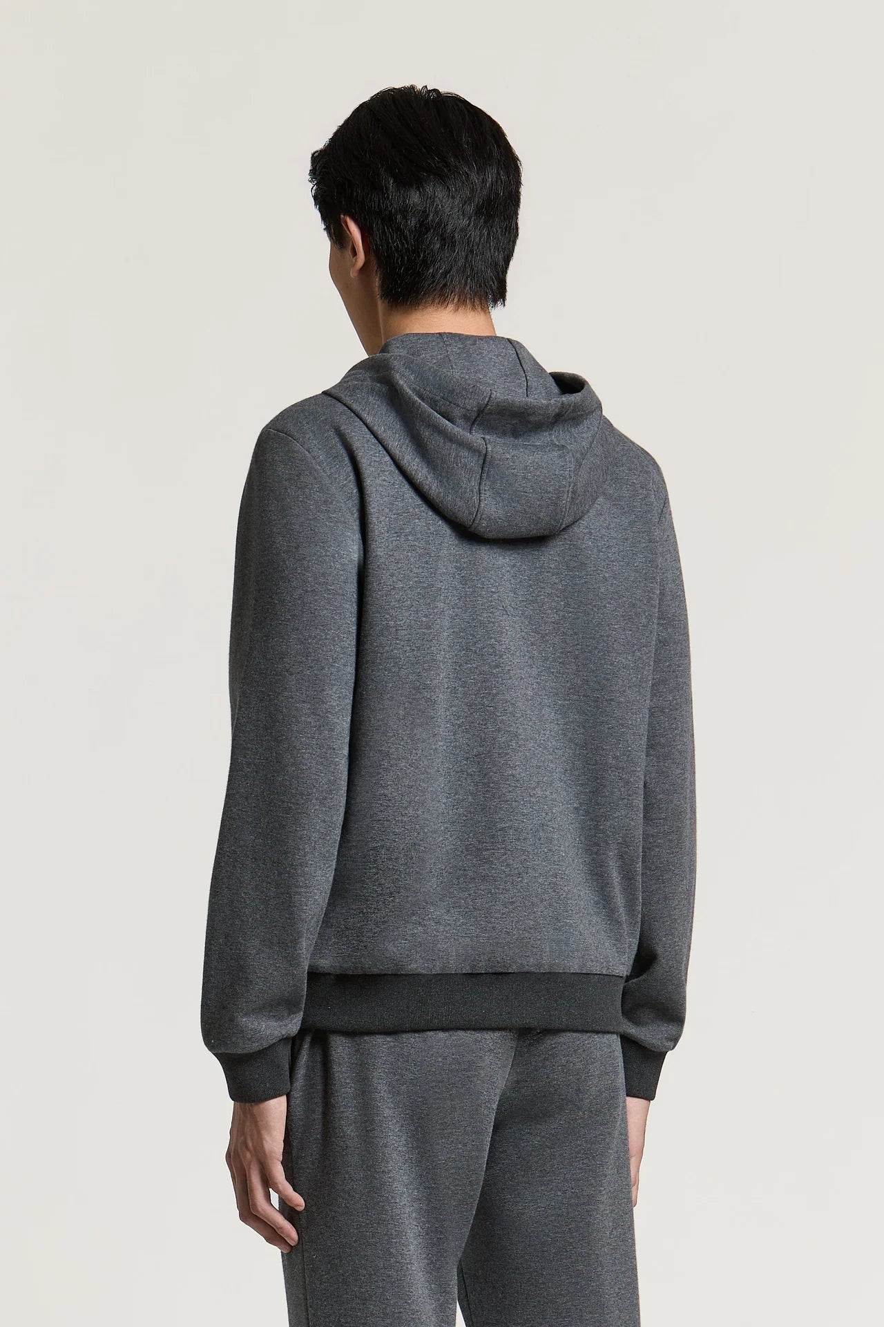 Dark grey hooded sweater with long sleeves, a hood, and ribbed cuffs and hem.