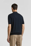 Dark blue knitted cotton polo shirt with short sleeves, ribbed cuffs and hem, and a thin light-toned stripe on the collar.