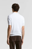 White pure cotton short-sleeve polo sweater with an open knit texture, ribbed cuffs and hem, seen from the back.