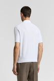 White pure cotton short-sleeved polo sweater with a subtle diamond knit pattern on the back, ribbed hem and cuffs.