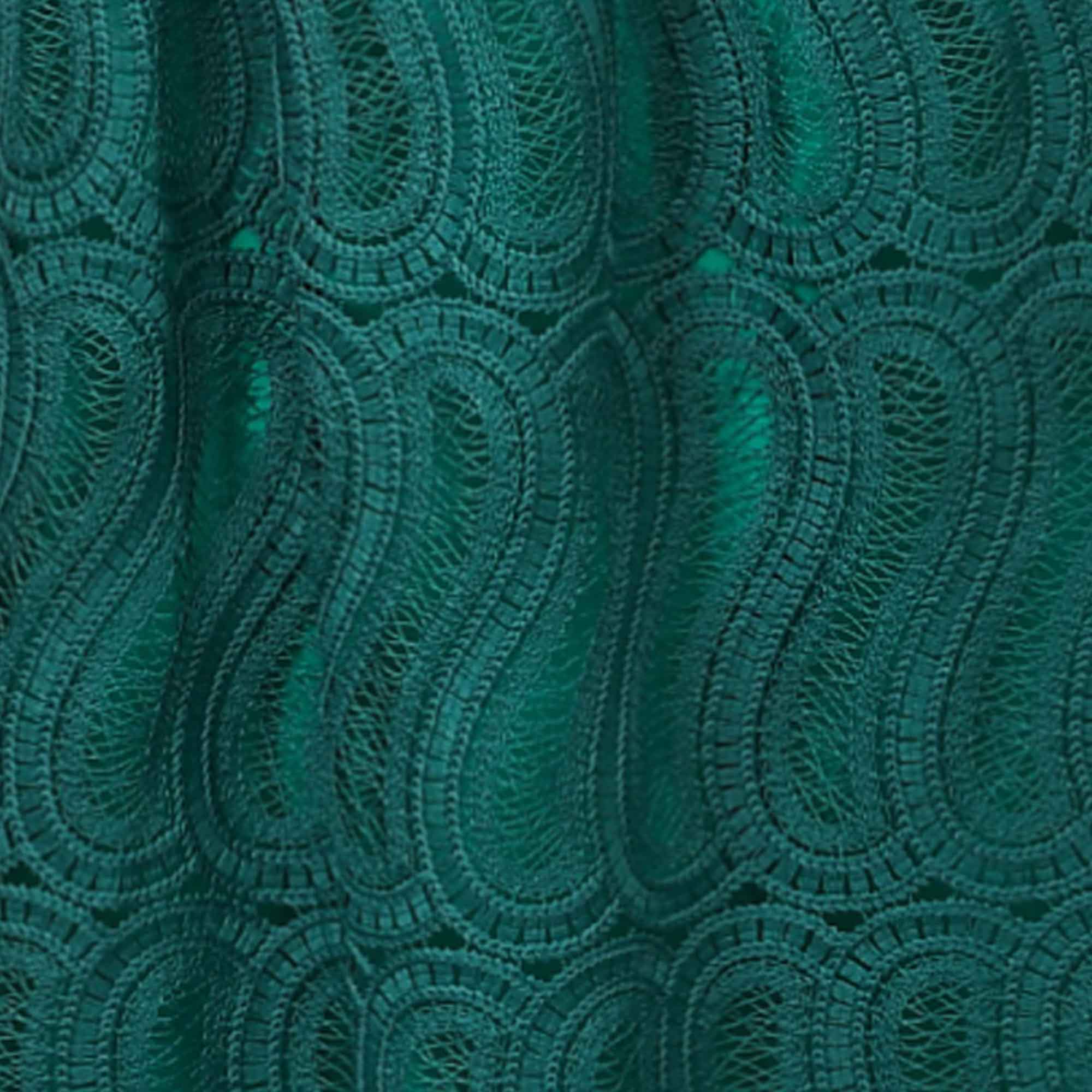 Green lace skirt with intricate, repeating paisley-like patterns over a solid green lining.