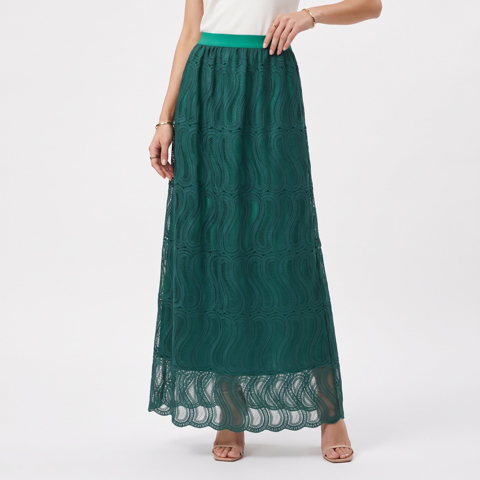 Green lace maxi skirt with a solid green lining. Features a wavy openwork pattern, scalloped hem, and a contrasting green ela