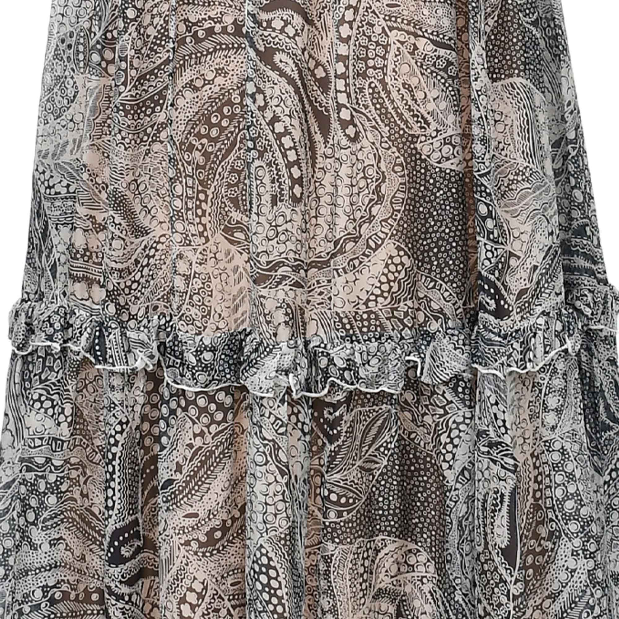 Sheer black, white, and beige abstract patterned tiered skirt with a ruffled seam and a thin white edge.