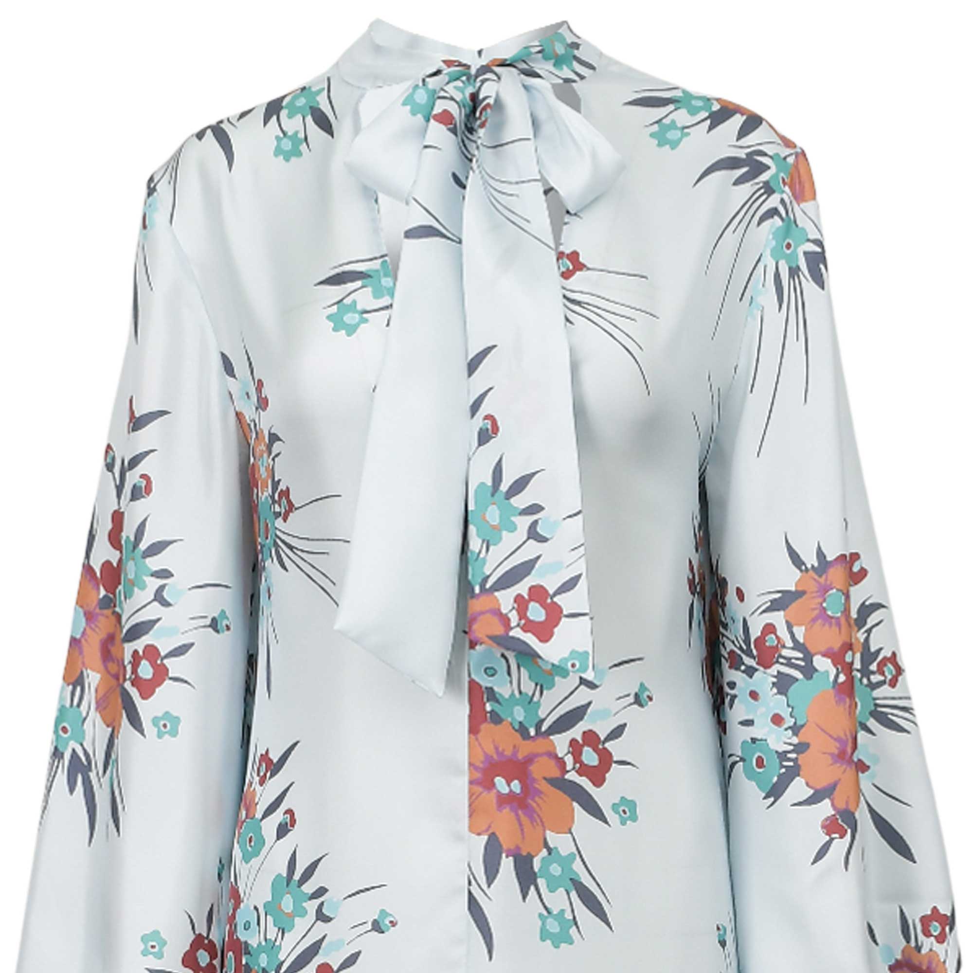 Light blue satin kaftan with a pussy-bow tie neck and long sleeves, featuring an all-over floral print in orange, red, and te