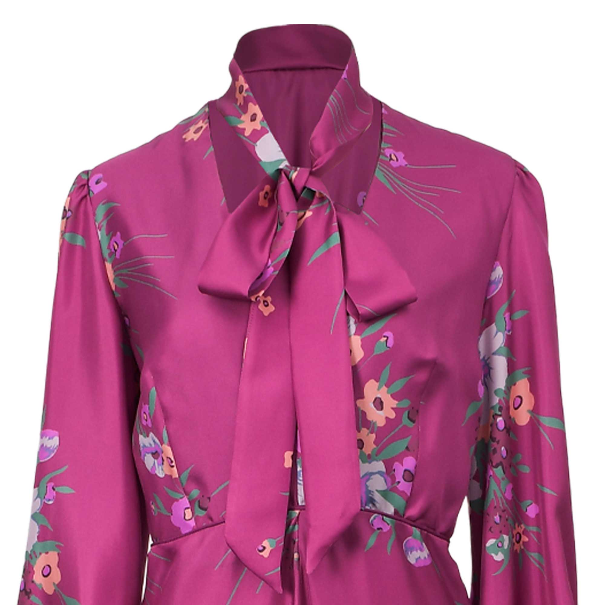 Fuchsia floral dress with a high collar, pussy-bow tie, and long sleeves with slight puff shoulders.