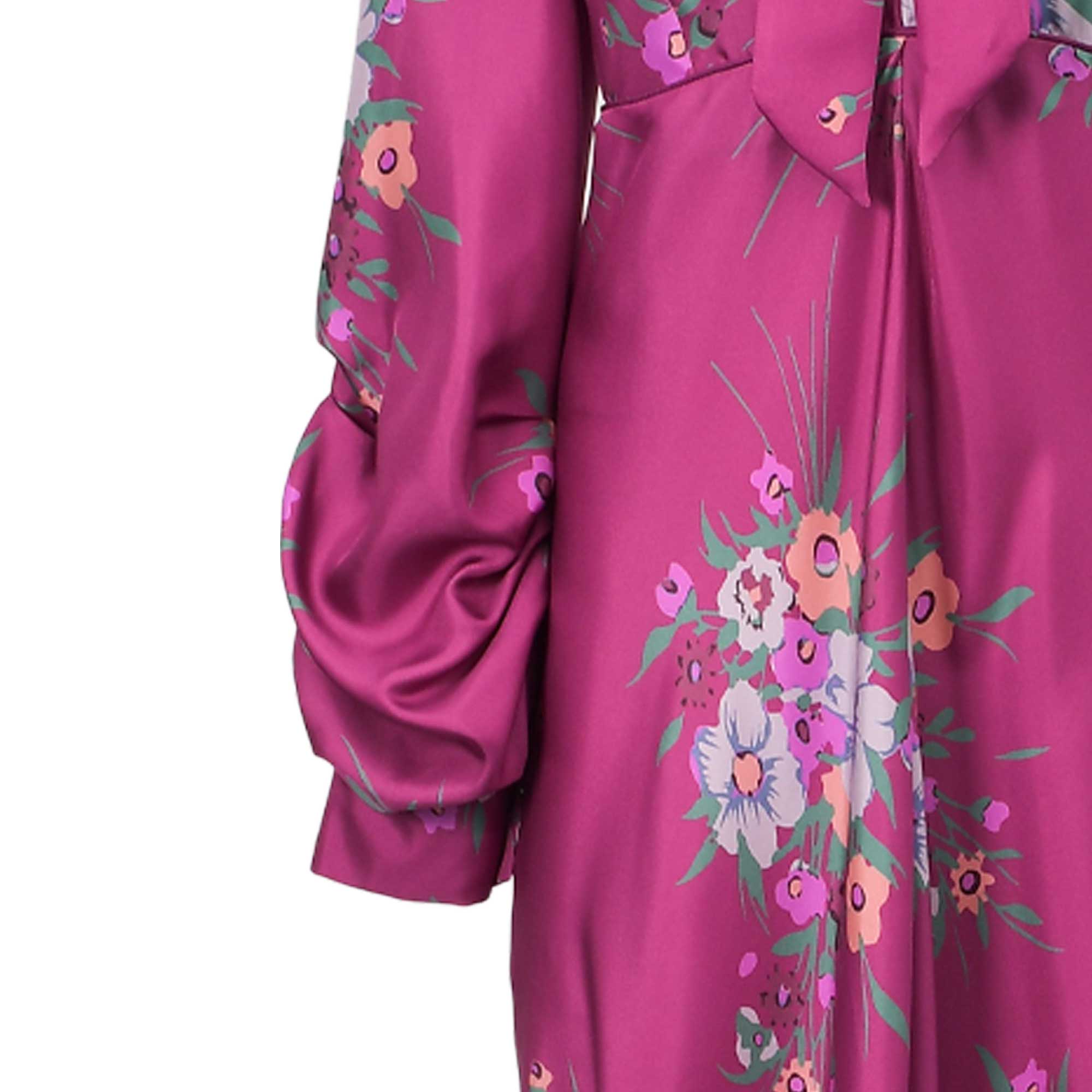 Fuchsia satin dress with a colorful floral print, featuring a gathered puff sleeve and a tie-neck detail.