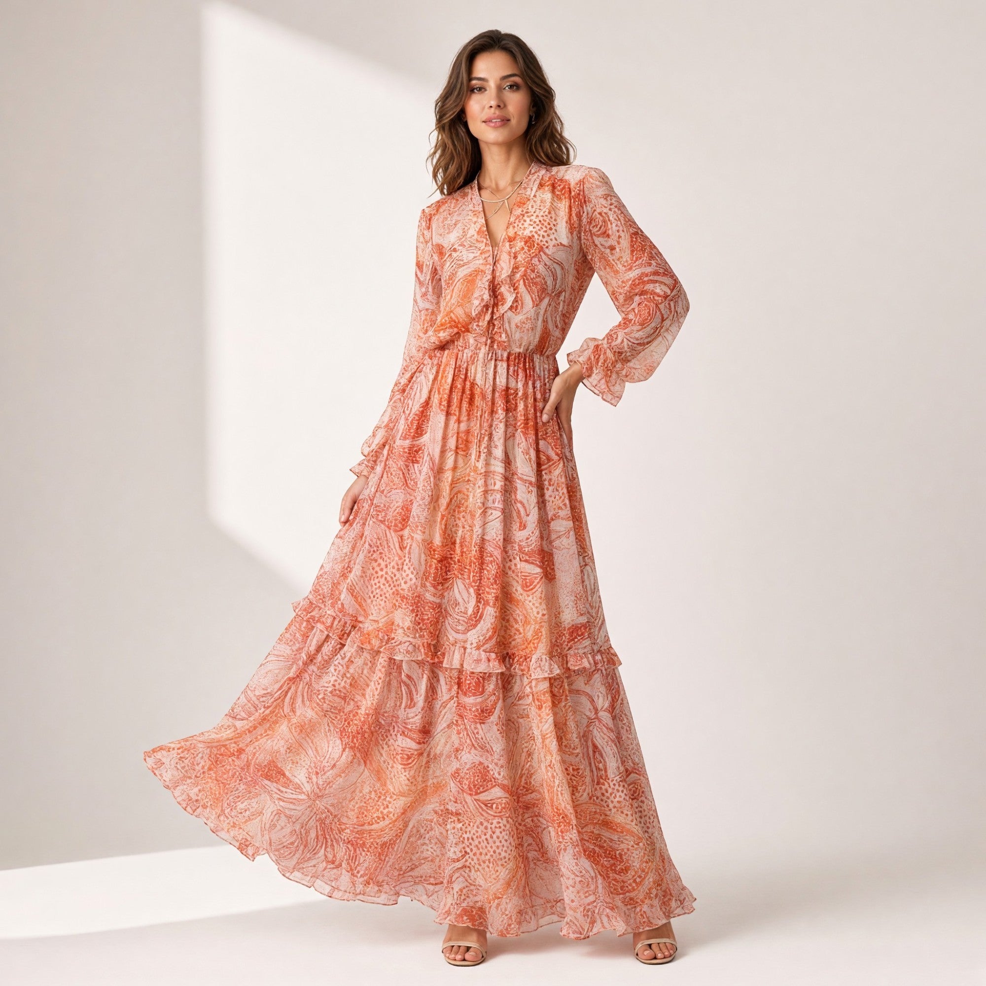 Multi coral maxi dress with a V-neck, long ruffled sleeves, shirred waist, and a tiered, ruffled skirt in a paisley pattern.