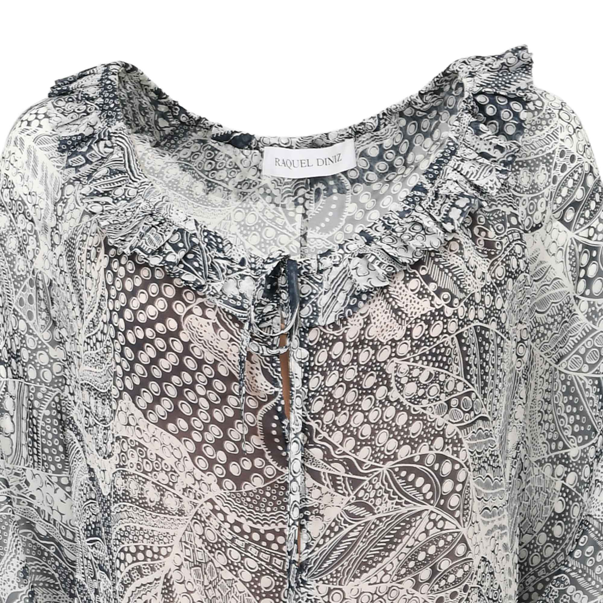 Sheer dark blue and white patterned top with a ruffled neckline and a tie-front detail.