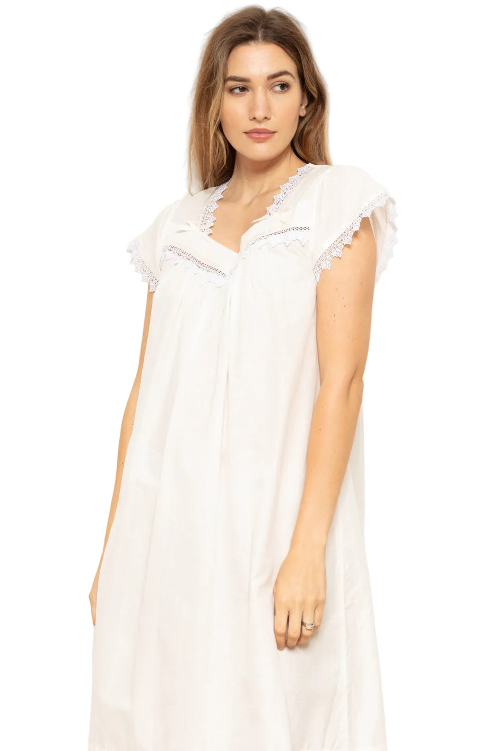 White supervoile nightdress with a V-neckline, cap sleeves, and white lace trim. Features a small bow detail.