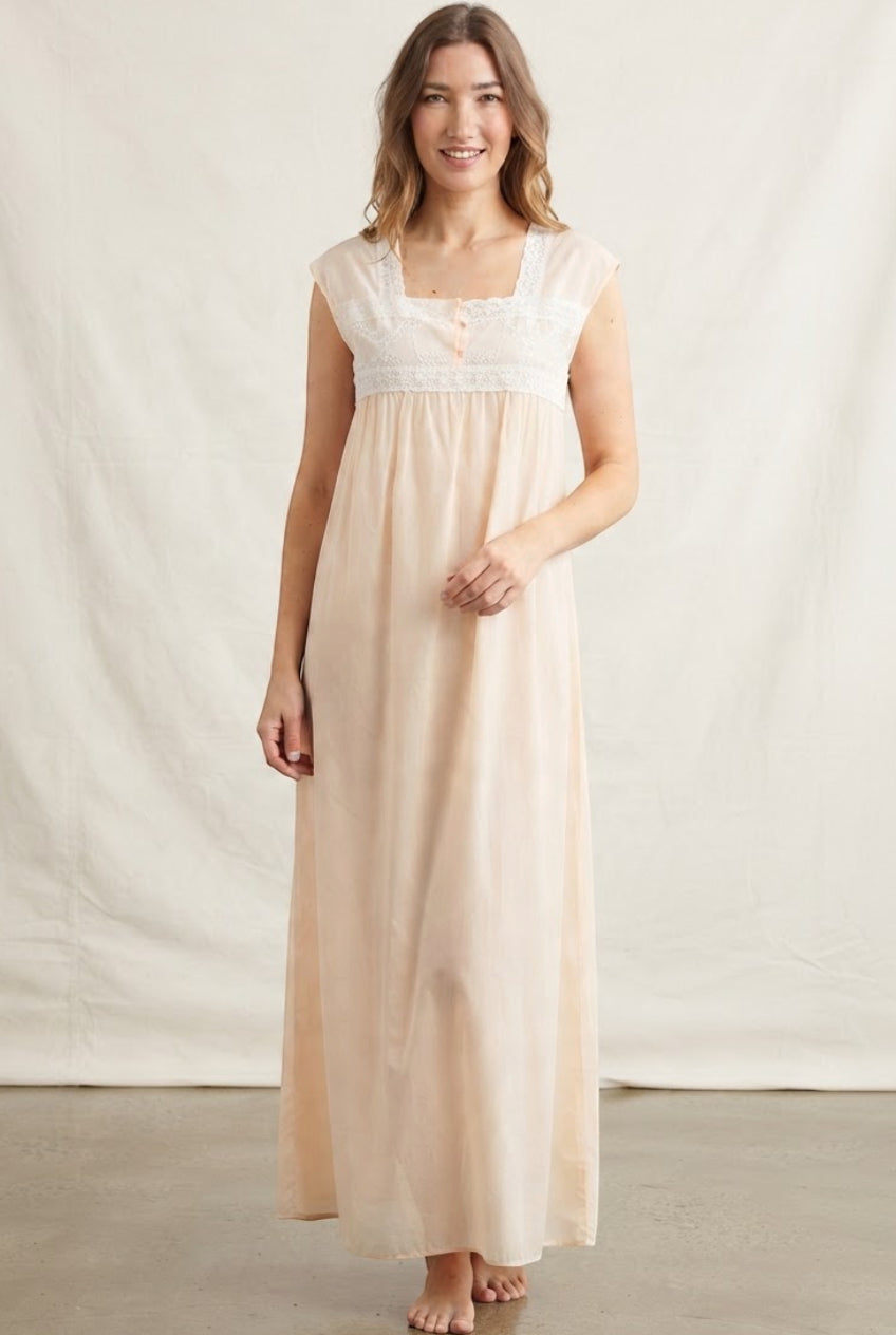 Light peach long abaya with a square neckline, cap sleeves, and white lace embroidery on the bodice and empire waist.